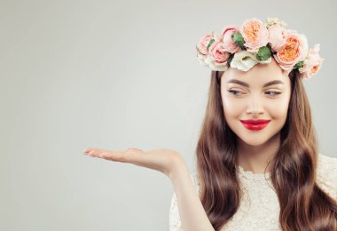 Beyaz arka planda boş eller gösteren güzel bir model kadın.