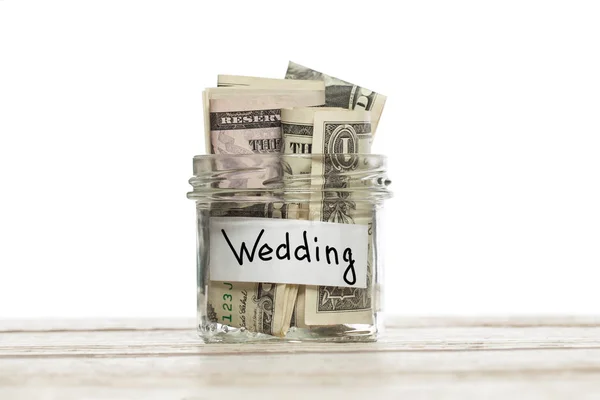 Risparmiare soldi per il matrimonio. Vaso di vetro con noi dollari su tavolo di legno isolato — Foto Stock