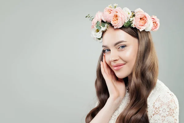 Gülümseyen kadın kıvırcık saçlı, doğal makyaj ve çiçekler portre — Stok fotoğraf