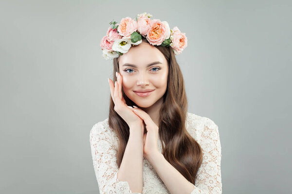 Cute Model Woman with Long Hair, Makeup and Spring Flowers Smiling on Gray Background