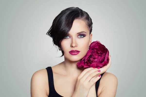 Όμορφο μοντέλο με φωτεινό μακιγιάζ και λουλούδι. Γυναίκα άνοιξη κάνει — Φωτογραφία Αρχείου