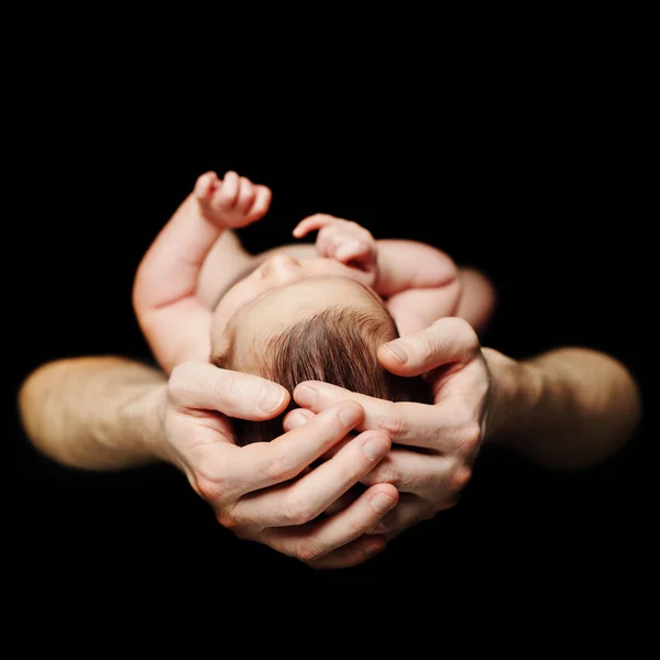 Father's hand and newborn baby on black background — Stock Photo, Image