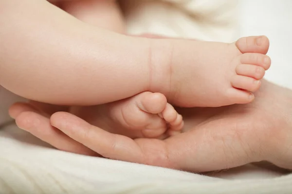 Parent holding in the hands feet of newborn baby — Stock Photo, Image