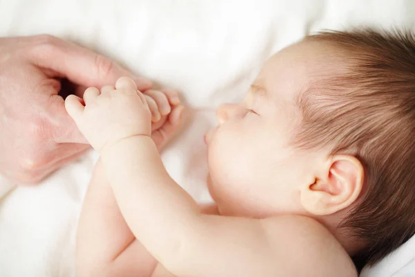 生まれたばかりの赤ちゃん寝て、父の手を握って — ストック写真
