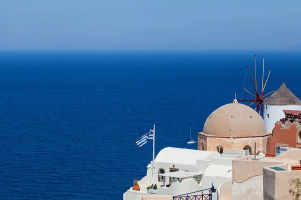 그리스 국기, 바다, 푸른 하늘과 마을이 있는 산토리니 스카이라인. — 스톡 사진