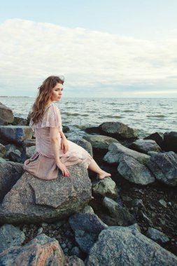 Okyanus kıyısında dinlenen güzel genç kadın, 