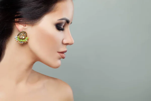 Cara de mujer joven con pendientes de joyería de moda con gema verde — Foto de Stock