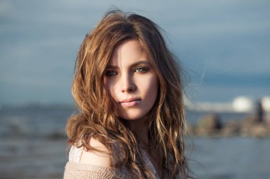 Okyanus kıyısında kıvırcık saçlı güzel model kız, 