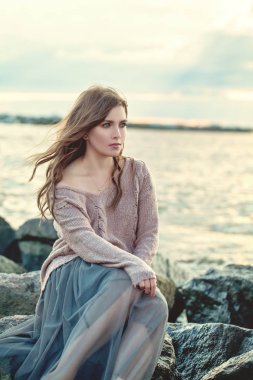 Geceleri okyanus kıyısında dinlenen güzel kadın