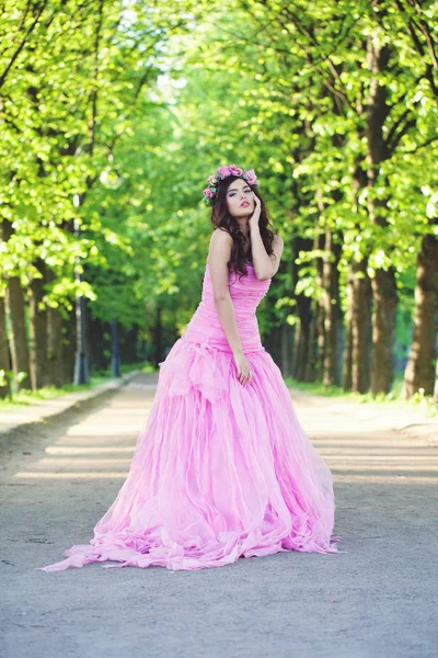 Bella donna in abito rosa nel parco — Foto Stock