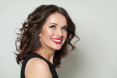 Mutlu kadın portresi. Makyaj ve kahverengi kıvırcık saçlı gülümseyen kız