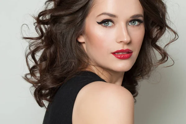 Perfecte model vrouw met make-up en bruin krullend haar. — Stockfoto