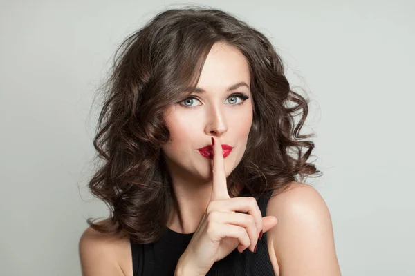 Gelukkige vrouw met vinger in de buurt van lippen, stilte concept — Stockfoto