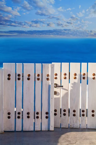 White wooden gate against sea and sky clouds — Stockfoto