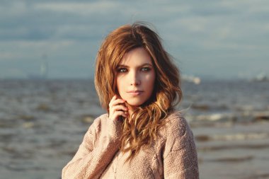 Güneşli günde okyanus kıyısında neşeli kadın