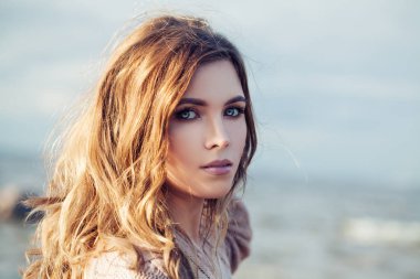 Güneşli bir günde uzun kıvırcık saçlı güzel şehvetli kadın