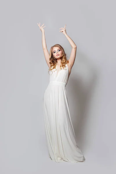 Mooie vrouw in modieuze witte jurk met handen omhoog — Stockfoto