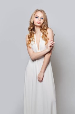 Güzel kadın portresi. Uzun kıvırcık saçlı sarışın model kız