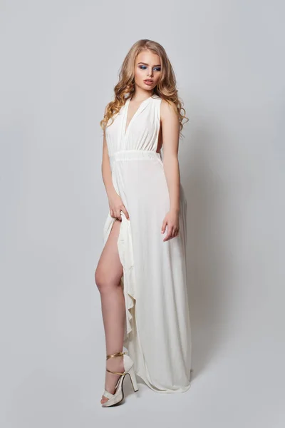 Vacker kvinna i vit klänning och höga klackar skor stående — Stockfoto