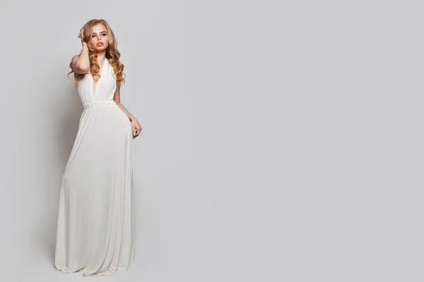 Beyaz arka plana karşı poz veren beyaz elbiseli mükemmel kadın — Stok fotoğraf