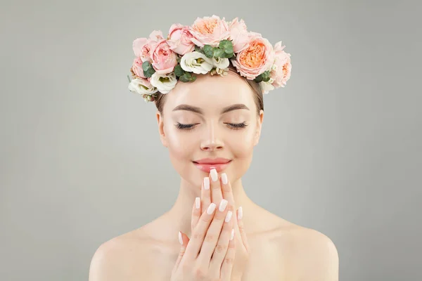 Perfekte junge Frau mit klarer Haut und Rosenblüten auf weißem Grund — Stockfoto