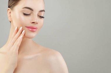 Gri arka planda açık tenli güzel bir kadın spa modeli.