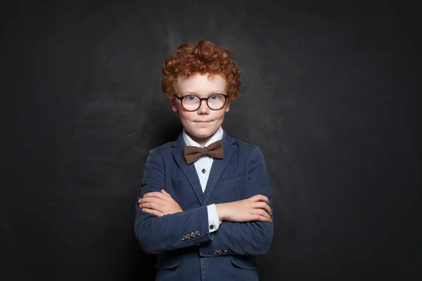 黒板の背景に対するスマートな子供の学校の男の子 — ストック写真