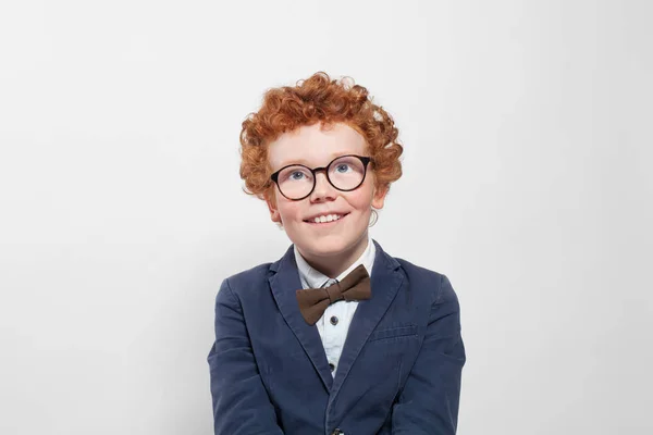 Симпатичный рыжий мальчик в очках смотрит на белом фоне — стоковое фото