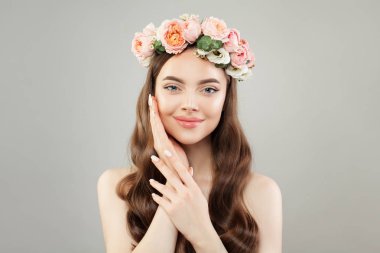 Açık cilde sahip spa kadın ve gri arka planda gül çiçekleri. 