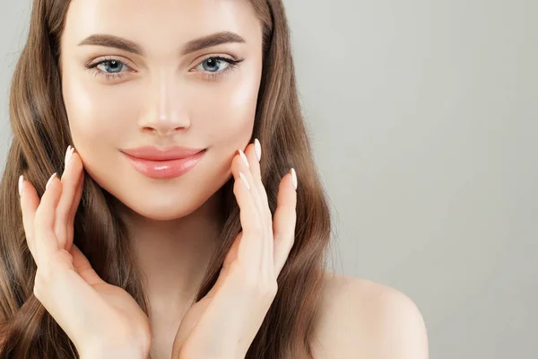 Mujer linda joven con la piel clara y cabello castaño saludable en gris — Foto de Stock