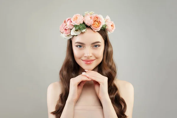 Jolie femme souriante à la peau claire, aux cheveux bouclés et aux fleurs — Photo