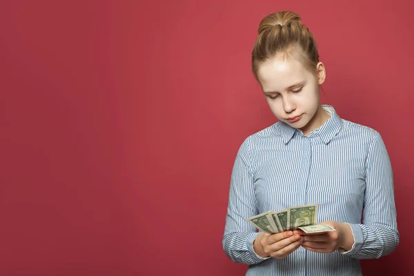 1ドルの現金を持っている若い不幸な困惑した女の子 — ストック写真