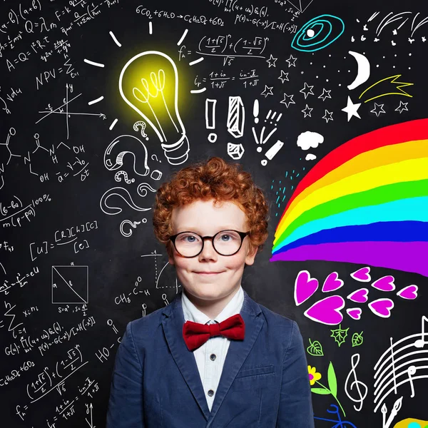 Enfant garçon avec des cheveux roux portant des lunettes sur le tableau noir — Photo