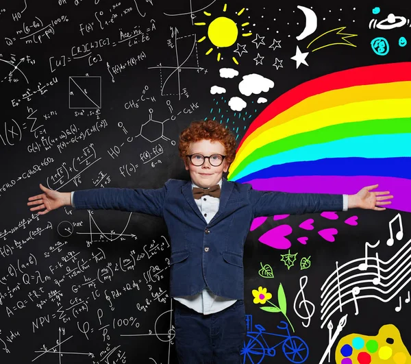 黒板の背景に宇宙を抱きしめる幸せな小さな男の子 — ストック写真