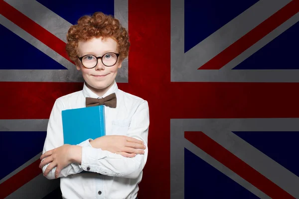 Sonriente niño estudiante en el fondo de la bandera del Reino Unido . —  Fotos de Stock