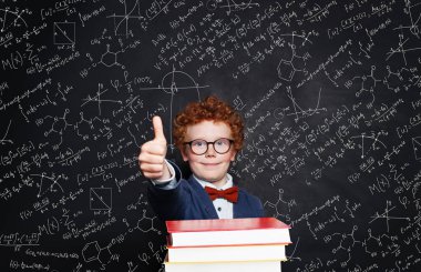 El başparmak yukarı ile takım elbise tutarak gülümseyen yakışıklı çocuk çocuk 