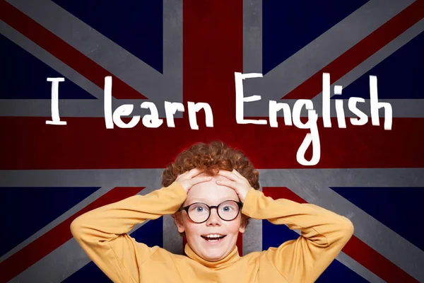 Sorprendió al joven en el fondo de la bandera del Reino Unido. Aprender inglés concepto — Foto de Stock