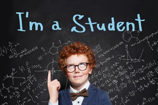 Smart Student Junge zeigt mit dem Finger auf Kreidetafel Hintergrund — Stockfoto