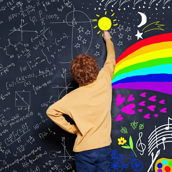 小男孩在黑板上画科学公式和艺术的scetch — 图库照片