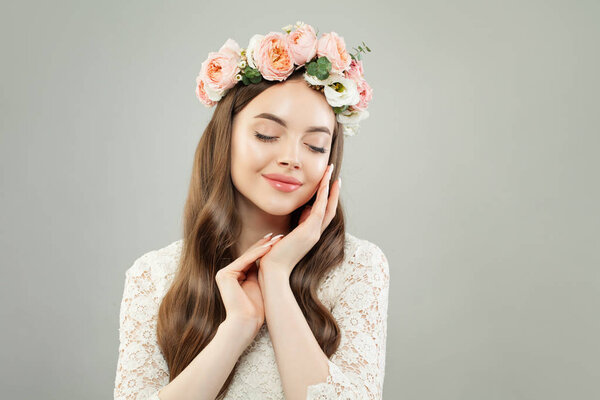 Cute woman with clear skin, long shiny hair and flowers relaxing