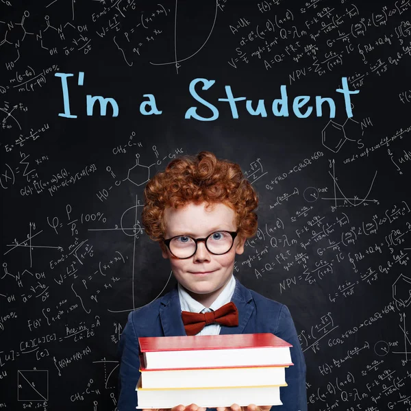 Kleiner Junge Student auf Tafel Hintergrund mit naturwissenschaftlichen Formeln — Stockfoto