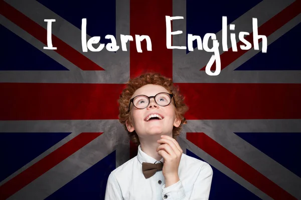 Malý školák s vlajkou Spojeného království a učit se anglicky — Stock fotografie