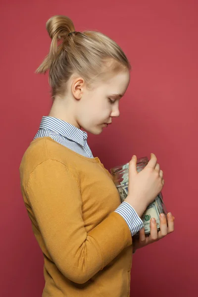 Cute teenager girl holding money cash in jar. Students fees,