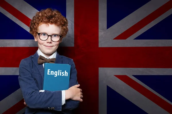 Chytrý kluk a učit se anglicky na pozadí vlajkového praporem — Stock fotografie