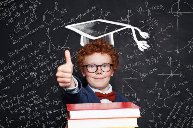 Sevimli çocuk çocuk eğlenmek ve tebeşir tahtası üzerinde başparmak gösteren 