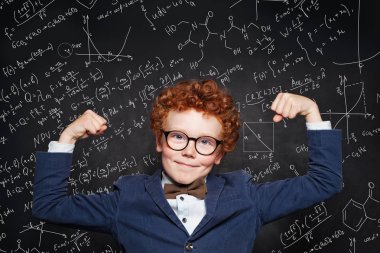 Tebeşir tahtası arka plan üzerinde Mutlu güçlü çocuk çocuk. Okula geri dön 