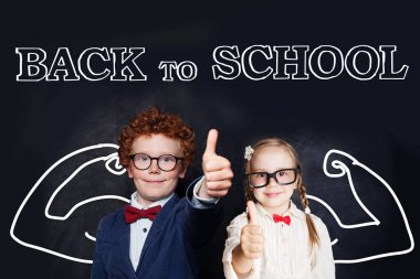 Okul üniforması içinde başarılı akıllı çocuklar kara tahtada eğleniyor