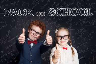 Okul üniforması içinde başarılı zeki çocuklar başparmak gösteren