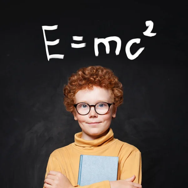 Jovem gênio feliz e fórmula científica contra quadro-negro — Fotografia de Stock