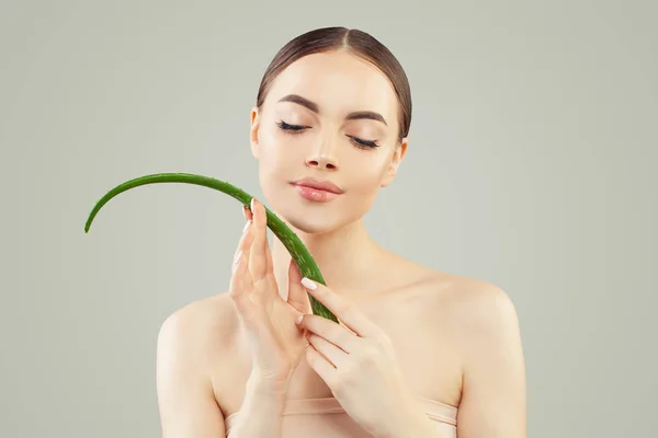 Mujer joven modelo spa con piel clara sosteniendo hoja de aloe vera . — Foto de Stock